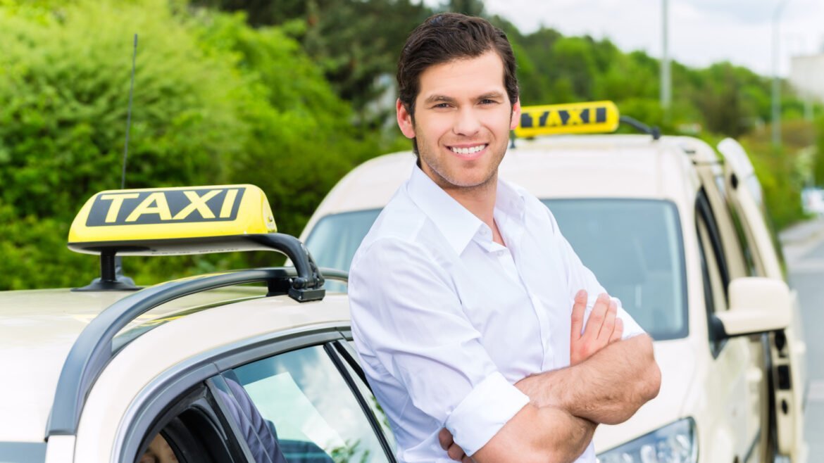 Driver in front of taxi waiting for clients